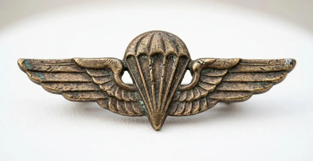 Gros plan macro sur un insigne métallique authentique de parachutiste américain exposé sur fond neutre avec éclairage muséal doux